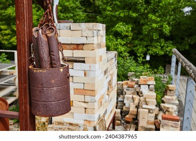 Rusty Bucket and Bricks at Construction Site with Greenery Background