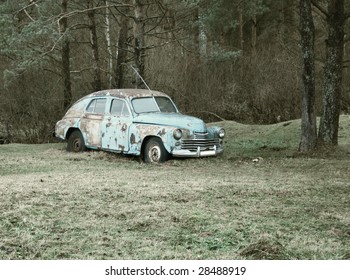 rusty car in the forest