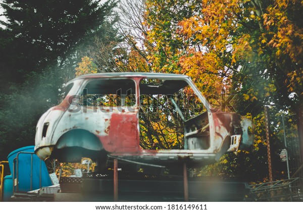 A rusty car at a scrap yard
