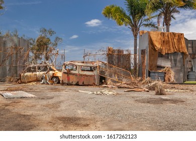 Rusty Car And Truck Next To A Fence In Junk, Wrecking Yard With Outdoor Storeroom And Palm Trees View, Abandoned Place, Gold Coast, Queensland, Australia