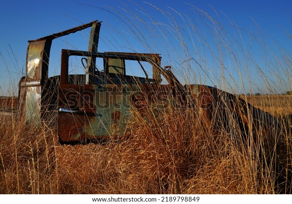 rusty car wrecks\
on a military site. the old cars serve as targets here. Nature is\
slowly overgrowing the\
wrecks.