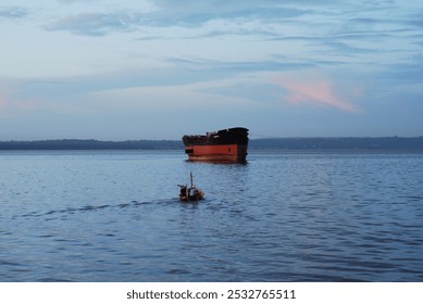 Rusty cargo ship anchored in a calm body of water. - Powered by Shutterstock