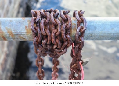 Rusty chain around metal bars at the port of Kiel