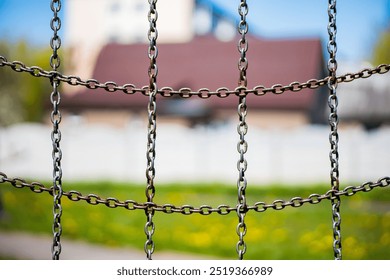 Rusty chain link fence blocking view with house in background - Powered by Shutterstock