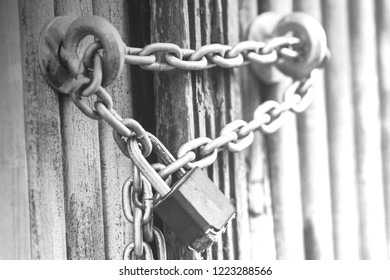 Rusty Chain with a lock on iron gate