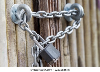 Rusty Chain with a lock on iron gate