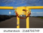 Rusty chain locking a yellow gate located at the end of the Chain of Craters Road in the Hawaiian Volcanoes National Park on the Big Island of Hawai