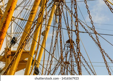 Rusty Chains Hanging From The Mast Of A Large Fishing Trawler Boat.