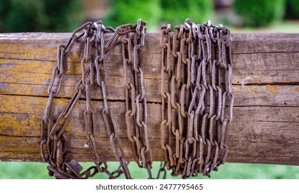 Rusty Chains Wrapped Around a Weathered Wooden Post