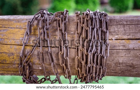 Rusty Chains Wrapped Around a Weathered Wooden Post