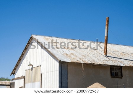 A rusty chimney on an old metal building