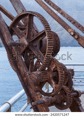 Rusty crane and gear wheels in Puerto de las Nieves fishing village in Gran Canaria, Spain