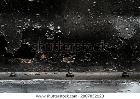 Rusty decayed black metal surface with cracked paint and corroded holes texture. Heavily weathered and corroded black metal plate.  Abstract backgrounds, Vintage themes, Representing neglect and aging