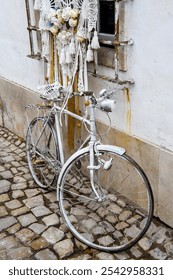 Rusty decayed old men's bicycle leaned against a wall of a house