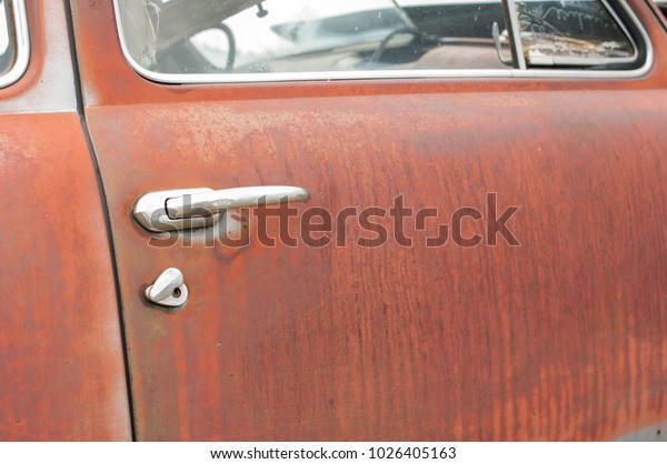 Rusty door and handle on\
antique car