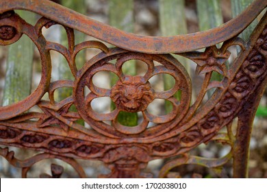 Rusty end of an old bench sitting in the forest.