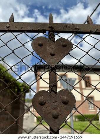 Rusty heart shaped ornaments of a chainlink fence