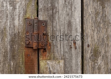 Rusty hinges on rotten doors. Old wooden boards. Background. Copy space