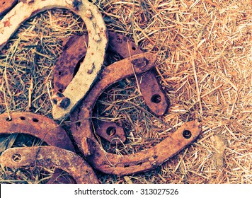 Rusty Horseshoes On A Straw Background - Rustic Scene In A Country Style. Old Iron Horseshoe - Good Luck Symbol And Mascot Of Well-being In A Village House In Western Culture.