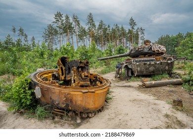 The Rusty Hull Of A Broken Tank Is Overgrown With Grass
