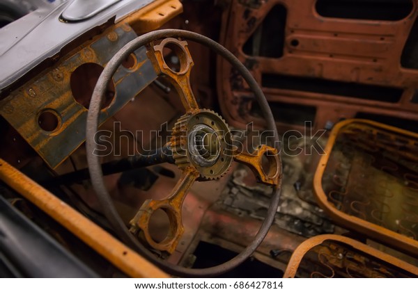 Rusty interior of an\
old car. Close up of Car steering wheel and dashboard panel with\
rust and dust.