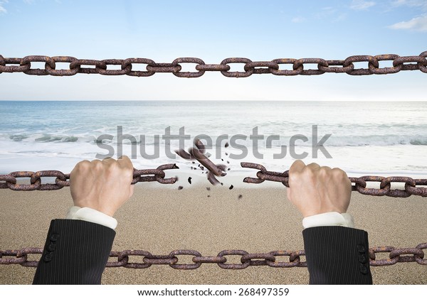 Rusty iron chains broken off by hands with\
natural sky sea\
background