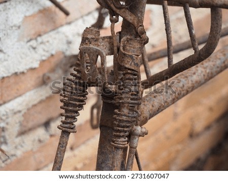 The rusty iron part of the spring or sock on an oldfashioned bicycle is visible close up