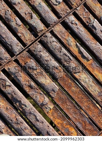 Rusty iron surface. Rust, corrosion, oxidation. Unused scaffolding and close-up surface. Crosslines. and vertical.