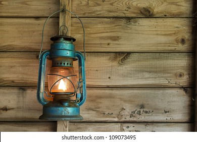 Rusty Lit Blue Lantern Hanging In An Old Shed