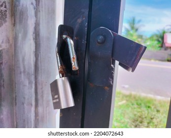 A Rusty Lock Hangs On The Fence.