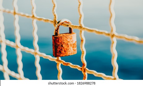 Rusty love padlock hanging on a bridge on a light blue sea background. 16 on 9. Makarska, Croatia - Powered by Shutterstock