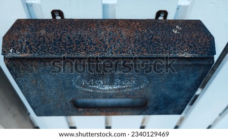Rusty mailbox attached to white wall