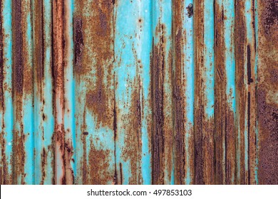 Rusty metal background with old layers of blue paint. Texture rusted shipping container.