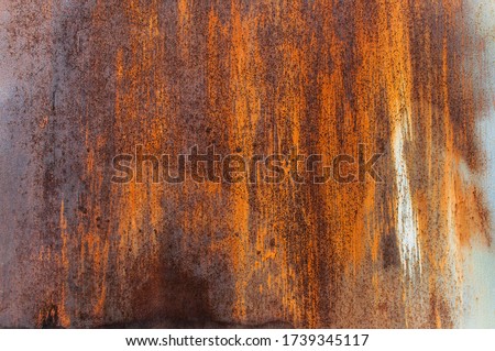 

Rusty metal background. The texture of the metal. Beautiful unusual background. Rusty painted metal wall. Rusty old background with streaks of rust. Rust stain.
