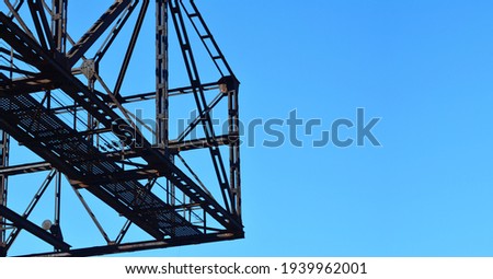 a rusty metal bridge construction and a blue sky as a suitable room for your topic