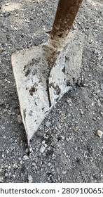 Rusty Metal Hoe Head Embedded in Gravel Soil – Close-Up of Traditional Gardening Tool