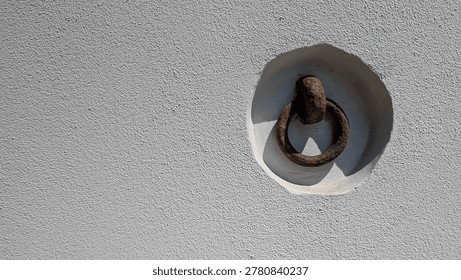 Rusty Metal Ring Embedded in White Wall