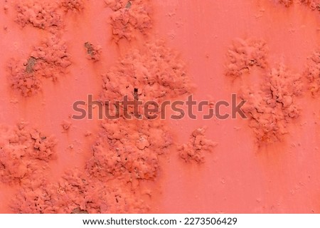 Rusty metal surface with peeling pink paint. Topic - metal corrosion and anti-corrosion treatment. Bright pink background. Metal is evenly covered with rust spots