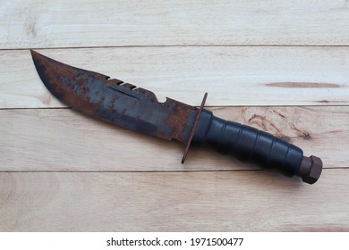 Rusty Military Knife Isolated On Wooden Background Closeup.