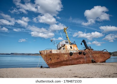 Rusty old abandoned iron fishing boat which is pulled out on the coast of the sea in Teriberka - Powered by Shutterstock