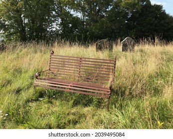 A rusty old bench in a graveyard