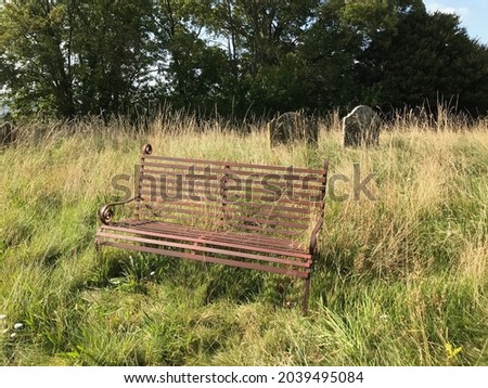 A rusty old bench in a graveyard