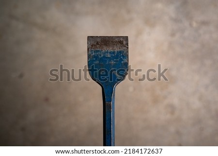 Rusty old blue scratched metal hand chisel for flooring.