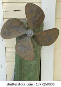 Rusty old boat propeller hanging outdoors
