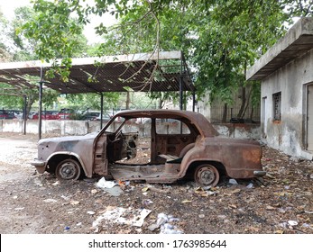 A rusty old car in a backyard 