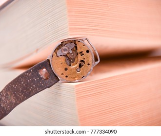 rusty old clock mechanism between book pages, concept