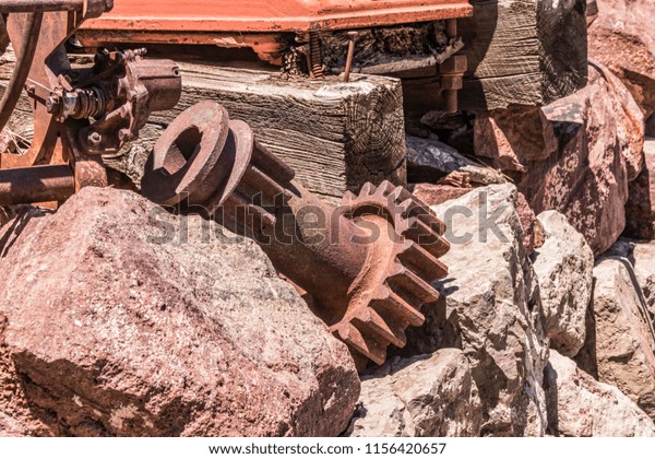 Rusty old gears\
& parts in a junk\
yard
