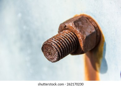 Rusty old industrial screw nut and bolt on light blue background close-up. Concept: old age, loneliness, healthcare.