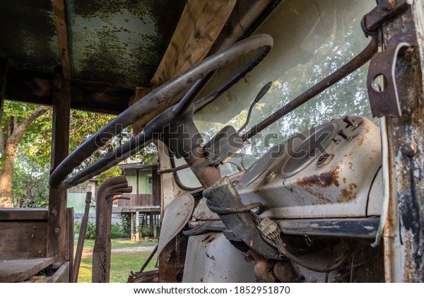 A rusty Old log truck cabin with Car\
steering wheel. Abandoned car, select\
focus.