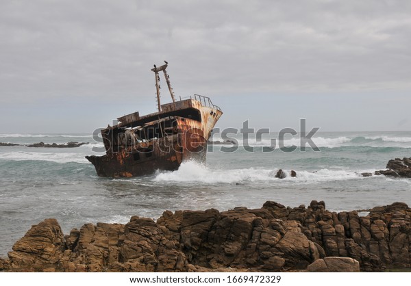 岩の上の錆びた古い難破船 の写真素材 今すぐ編集